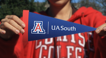 AZCAST student holding a UA South triangle spirit banner